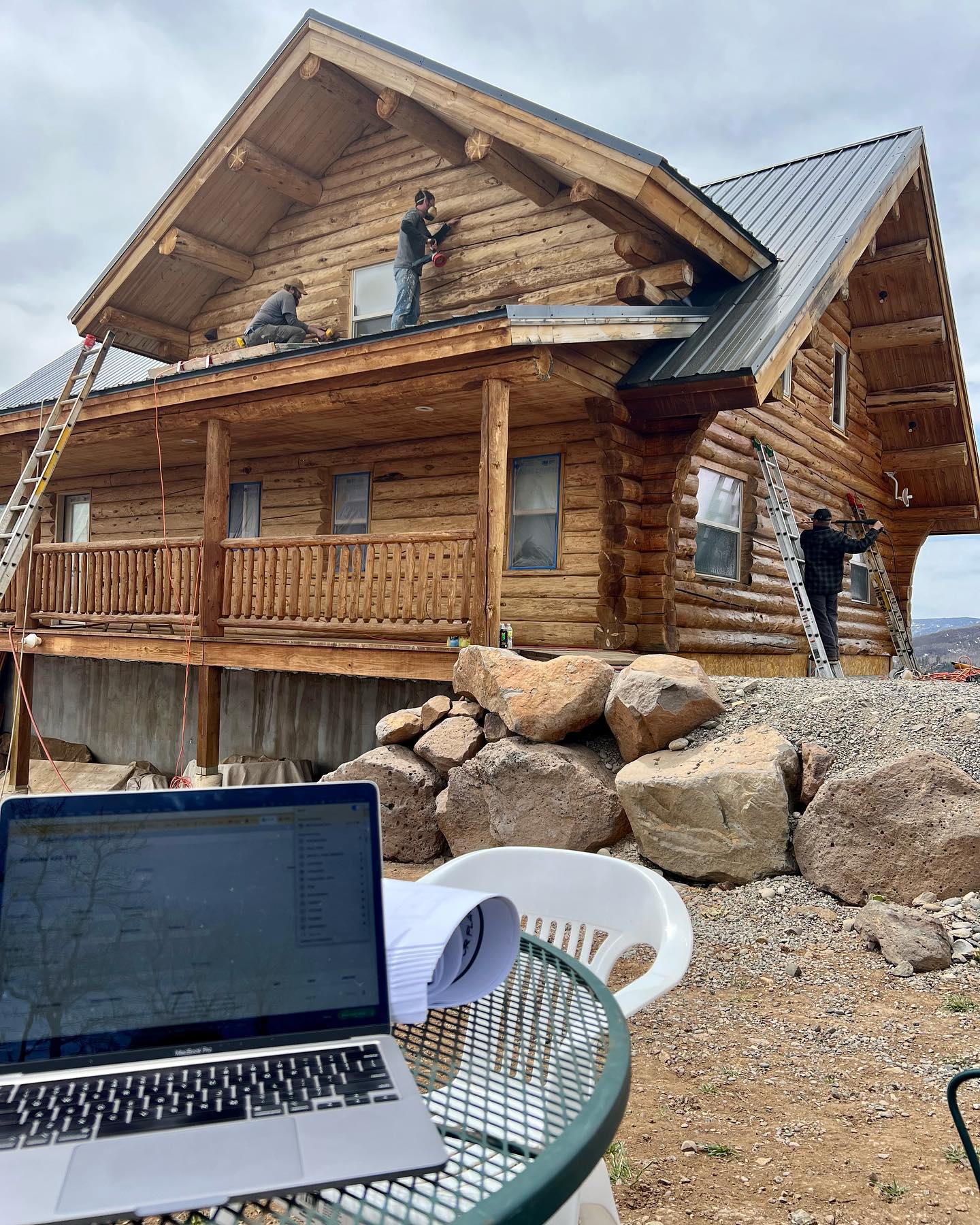 Log home refinishing with maintenance coat restoring color and UV protection on sun-faded logs