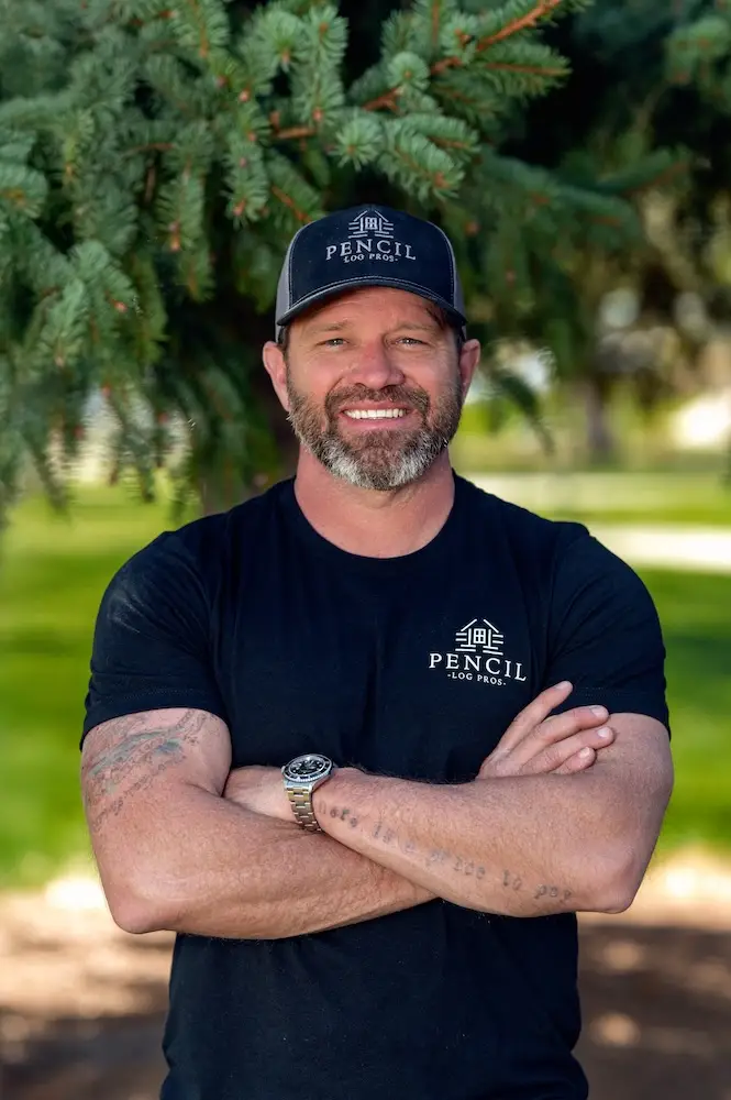 Brad Siler, Owner of Pencil Log Pros, standing at a Colorado log home restoration project.