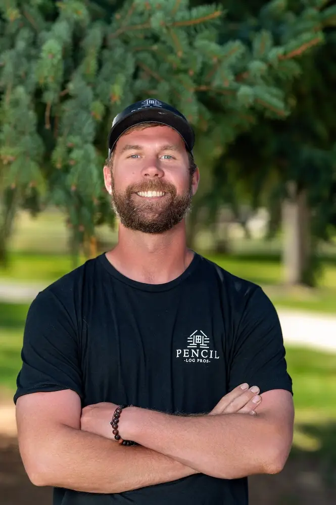Taylor Watkins, Foreman and social media manager at Pencil Log Pros, at a Colorado log home restoration project.