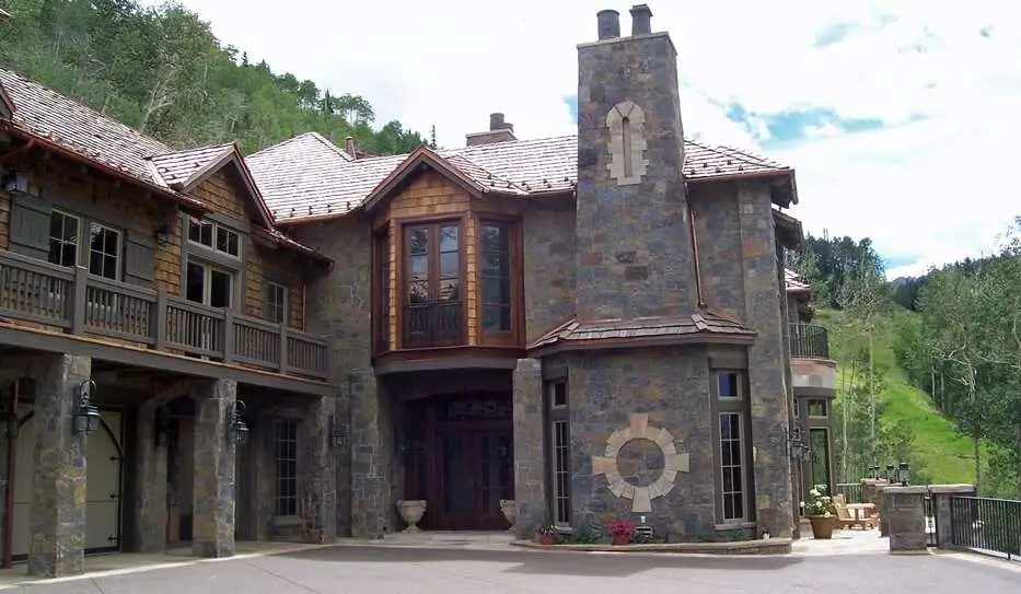 A massive handcrafted log and stone mountain home built by Frontier Log Homes in Montrose, Colorado, showcasing full-round logs, timber trusses, and a stone exterior framed by panoramic mountain views.
